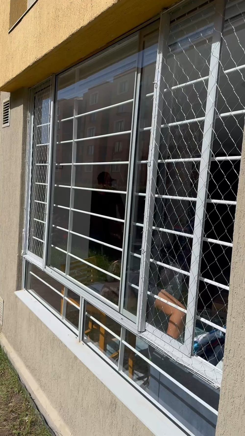 Ventana de habitación con malla de protección tensada